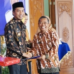 Bupati Ahmad Dawami sedang menjabat tangan Kepala Bagian Humas Protokol Pemkab Madiun Herry Supramono yang juga sudah purna tugas.