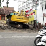 Alat berat tengah mengerjakan proyek box culvert di depan kantor DPD II Golkar Gresik, jalan Panglima Sudirman. foto: SYUHUD/ BANGSAONLINE