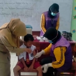 Petugas UPTD Puskesmas Mrican, Kota Kediri, saat melakukan imunisasi pada salah satu pelajar SD. Foto: Ist