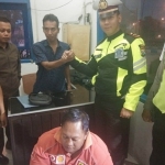 Pelaku berbaju merah (duduk di bawah) saat diamankan petugas Satlantas Polres Ngawi.