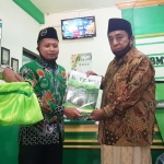 KH. Drs. M. Jamhuri, Wakil Ketua MWC NU saat menyerahkan santunan secara simbolis.