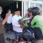 Kiai Asep Saifuddin Chalim, pendiri ASC Foundation, saat membagikan paket sembako kepada driver ojol.