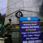 Petugas Dispol PP Pemkab Gresik saat hendak menurunkan salah satu reklame yang diketahui ilegal. foto: SYUHUD/ BANGSAONLINE