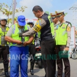 Satlantas Polres Blitar saat memaikan rompi kepada Supeltas yang berjaga di perlintasan kereta api tanpa palang pintu.