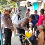 Kapolsek Wonoayu, AKP Hafid Dian Maulidi, saat membesuk warga Desa Pilang yang sakit.