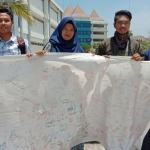 Sejumlah mahasiswa UTM Bangkalan saat menggelar aksi solidaritas 1.000 tanda tangan tolak UU KPK hasil revisi dan RUU KUHP, Senin (23/09/2019).
