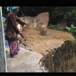 Mahrusah menunjukkan bibir sungai yang semakin mendekati rumahnya. foto: AHMAD/ BANGSAONLINE