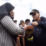 Bupati Kediri Hanindhito Himawan Pramana saat ikut membagikan durian kepada salah satu warga. Foto: Ist.