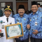 Dari kiri, Camat Sangkapura Abdul Adhim, Gubernur Jatim Soekarwo, dan Bupati Sambari menunjukkan piagam.