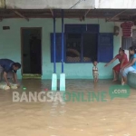 Air banjir masih menggenangi perumahan warga Desa Curahmalang, Kecamatan Sumobito, Kabupaten Jombang, Selasa (31/1). foto: RONY SUHARTOMO/ BANGSAONLINE