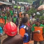 Warga bersama relawan membersikan batang pohon.