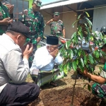 Pengasuh Pondok Pesantren Amanatul Ummah, Prof. Dr. K.H. Asep Syaifuddin Chalim M.A. atau yang akrab disapa Kiai Asep bersama anggota Koramil 0815/16 Pacet saat menanam bibit pohon durian. 