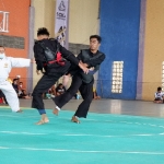 Atlet pencak silat kategori tanding putra sedang bertarung di Gedung Soka Perumahan Griya Utama Bangkalan, Sabtu (2/10/2021). foto: FAUZI/ BANGSAONLINE