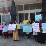 Puluhan wali murid membentangkan aneka poster saat demo di kantor Disdikbud Jombang. foto: AAN AMRULLOH/ BANGSAONLINE