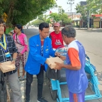 Para mahasiswa saat membagikan sembako dan nasi kota kepada masyarakat di Nganjuk.