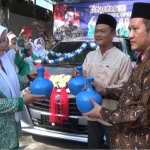 Iwan Zunaih (kanan pegang kendi) saat menyerahkan bantuan mobil dari Pemprov Jatim kepada Ketua PAC Fatayat NU Ujungpangkah Jazilah. foto: ist.