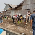 Anggota TNI dan Polri gotong royong membangun rumah milik salah satu warga yang terdampak bencana.