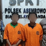 Dua tersangka saat diapit petugas dari Polsek Asemrowo.