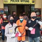 Petugas dari Polsek Wiyung saat menunjukkan barang bukti beserta tersangka.