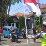 Polisi lalu lintas di Banyuwangi menghentikan semua kendaraan menjelang detik-detik Proklamasi Kemerdekaan Republik Indonesia, di Simpang Lima Banyuwangi, Selasa (17/8/2021).