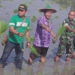 BERSAMA – Camat Ngawi, Kades Grudo, Kadin Pertanian, Kapten Armed Sugiartono, dan Polsek Ngawi saat tanam padi massal bersama rakyat. foto: Agus Setiawan/BANGSAONLINE