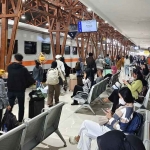 Suasana naik-turun penumpang di stasiun kereta api.