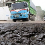 Kendaraan berat melintas di Jalan Harun Thohir yang rusak parah. foto: syuhud/ bangsaonline