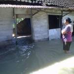 ?Warga mengamati rumah yang diterjang banjir. Foto:eky nur hadi/BANGSAONLINE