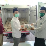 Muhammad Al-Barra (Gus Bara) berbaju putih menyerahkan paket sembako secara simbolik kepada Ketua PCNU Kabupaten Mojokerto KH Abdul Adzim Alwi di Kantor PCNU Mojokerto Jawa Timur disaksikan Sobirin, Kamis (16/4/2020). foto: MA/BANGSAONLINE.com