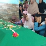 Jenazah saat di rumah duka. Istri Rabagus sedang mengusap air matanya.