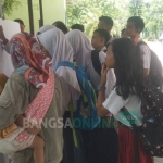 Para siswa SD melihat hasil pengumuman OSN di SMPN 1 Trenggalek. foto: HERMAN S/ BANGSAONLINE