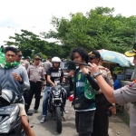 Kapolres Bangkalan AKBP Rama Samtama Putra meminta salah satu Bonek asal Kamal untuk memakai helm. foto: AHMAD FAUZI/ BANGSAONLINE