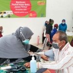 Salah satu petugas dari pelayanan mobil klinik Indosat Ooredoo saat memeriksa dan melayani korban banjir bandang di Kota Batu.