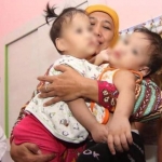 Gubernur Jawa Timur Khofifah Indar Parawansa dengan penuh keibuan menggendong bayi kembar siam Akila Dewi Syabila dan Azila Dewi Sabrina asal Kendari, Sulawesi Tenggara saat menjenguk di RSU dr Soetomo Surabaya, Senin sore (5/8/2019). foto: Humas Pemprov Jatim/BANGSONLINE.com