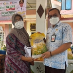 Kepala Disperindag Kabupaten Mojokerto, Iwan Abdillah, saat melayani warga yang membeli beras.