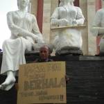 Abdul Basith menggelar aksi sendiri di depan tiga patung  sambil membawa poster penolakan, kemarin. foto : nanang ichwan/BangsaOnline.com