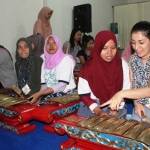 Mahasiswa asal mancanegara ini sedang menjajal alat musik gamelan.