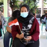 Salah satu warga dengan bendera merah putih kecil di tangannya. Foto: Ist