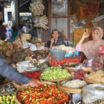 Atik, pegagang sayur mayur di Pasar Besar Ngawi saat melayani pembeli. foto: ZAINAL ABIDIN/ BANGSAONLINE