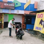 Sejumlah karyawan New Samba Karoke membuka usaha cuci motor di halaman parkir.
