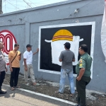 Aparat TNI-Polri saat mendatangi lokasi mural bergambar bendera Jolly Roger One Piece yang kini telah dihapus