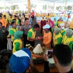 Bupati Nyono saat memberikan potongan tumpeng kepada Sugiarti, anggota pasukan kuning wanita dari BLH. foto: ROMZA/ BANGSAONLINE