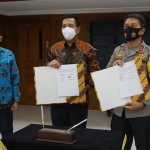 Kapolda Jawa Timur Irjen Pol Dr. Nico Afinta dan RCEO Region 8 PT. Bank Mandiri I Gede Raka Arimbawa menunjukkan dokumen kerja sama beasiswa yang telah ditandatangani.