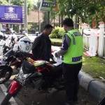 Pengendara menunggu polisi yang memroses surat tilang. foto: roni suhartomo/ BANGSAONLINE