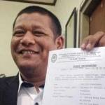 TUNJUKKAN – Didik Dharmadi menunjukkan surat tak pailit milik Lucky Kurniasari. foto: maulana/BANGSAONLINE