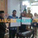 Wali Kota Kediri, Abdullah Abu Bakar, bersama Ketua KPU Kota Kediri, Pusporini Endah Palupi, saat menunjukkan NPHD Pilkada yang baru ditandatangani, dan disaksikan Ketua Bawaslu Kota Kediri, Yudi Agung (paling kanan). Foto: MUJI HARJITA/ BANGSAONLINE