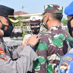 Kabag Ops Polresta Sidoarjo Kompol Trie Sisbiantoro memasangkan badge kepada personel yang terlibat dalam Operasi Keselamatan Semeru 2021.