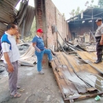 Kapolsek Krembung AKP Purwanto (topi merah) saat meninjau lokasi gudang plastik yang terbakar.