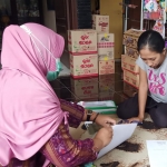 Petugas saat mendata salah satu pedagang yang ikut program Kurnia. foto: ist.