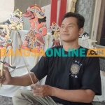 Ki Brodin saat menunjukkan wayang klitik buatannya yang menggambarkan tokoh seorang Raja Kediri, Sri Aji Joyoboyo. Foto: MUJI HARJITA/ BANGSAONLINE